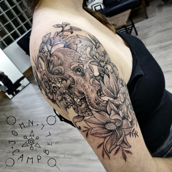 Black and grey fine line upper arm and shoulder octopus with flowers tattoo. Book a custom tattoo with John at Sacred Mandala Studio - Durham, NC.